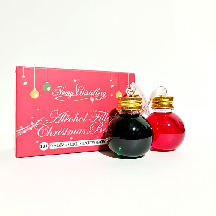Boozy Baubles Christmas 2023. Raspberry and Lime Flavoured Vodka Baubles. Displayed onnext to gift box.