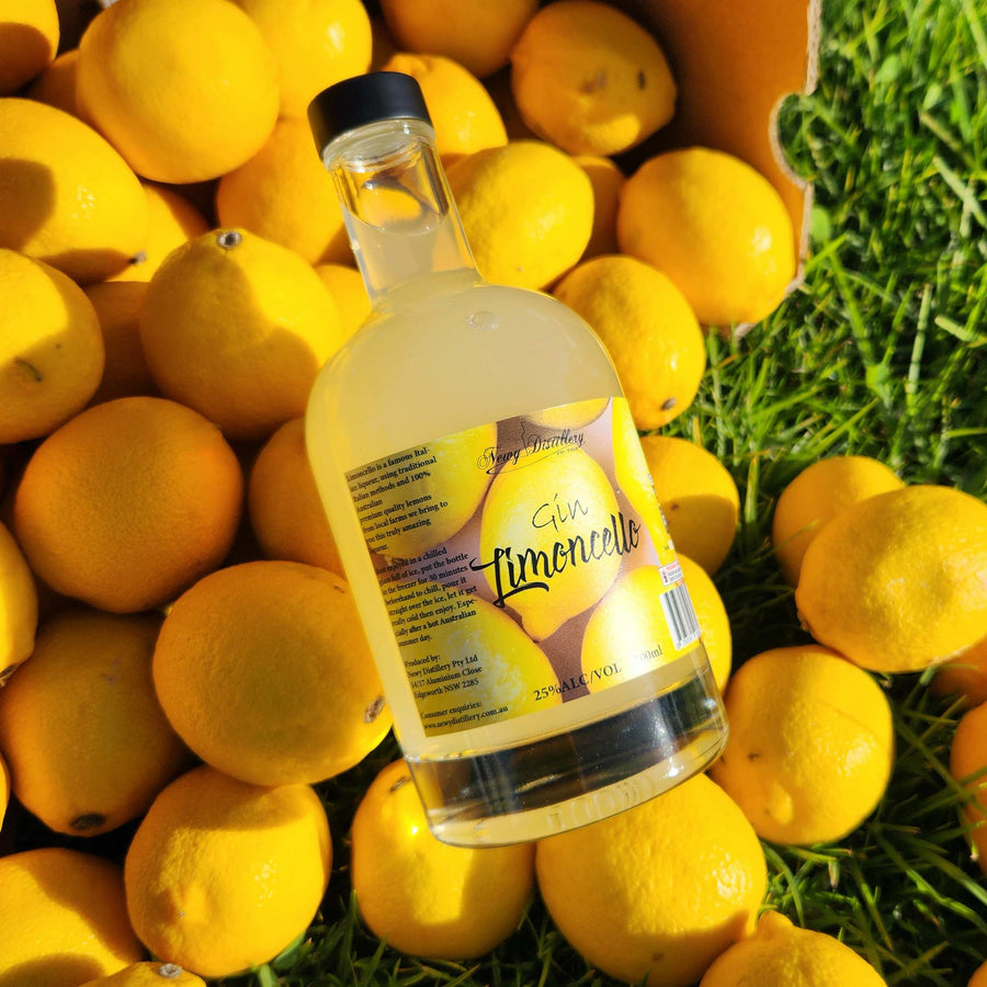 Gin Limoncello by Newy Distillery. 500ml gin limoncello bottle displayed on lemons in fruit crate. 500ml Limoncello Fruit Gin Liqueur.