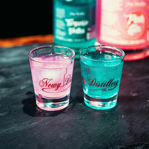 50ml shot glasses by Newy Distillery. One glas with pink vodka, one glass with turquoise vodka.