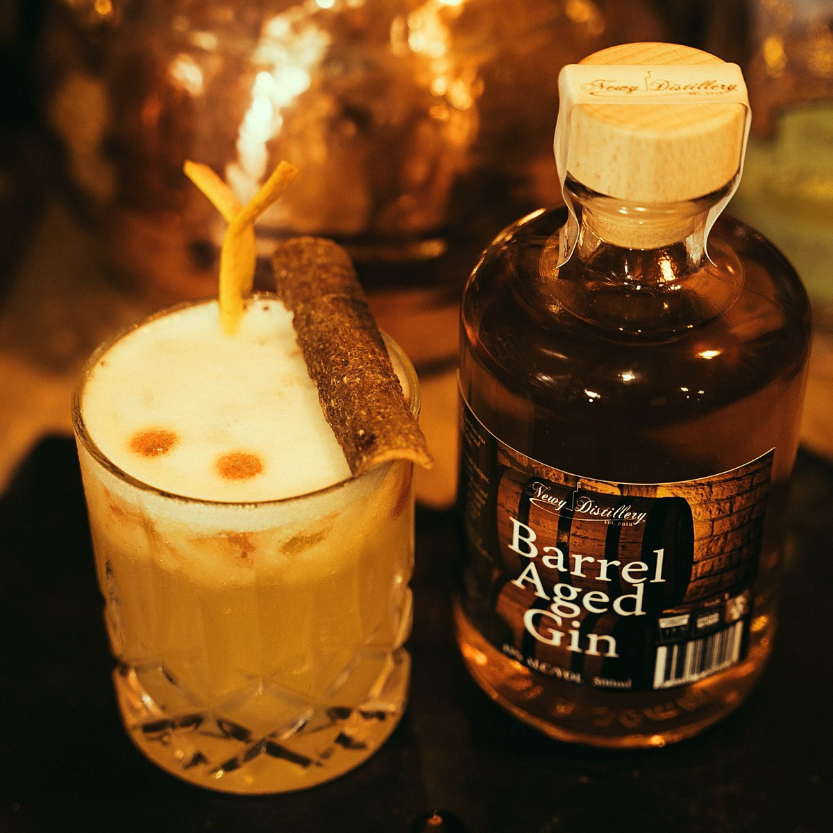 Newy Distillery Port Barrel Aged Gin. Craft gin. 500ml bottle. Displayed next to Barrel aged gin sour cocktail, by Newy Distillery.