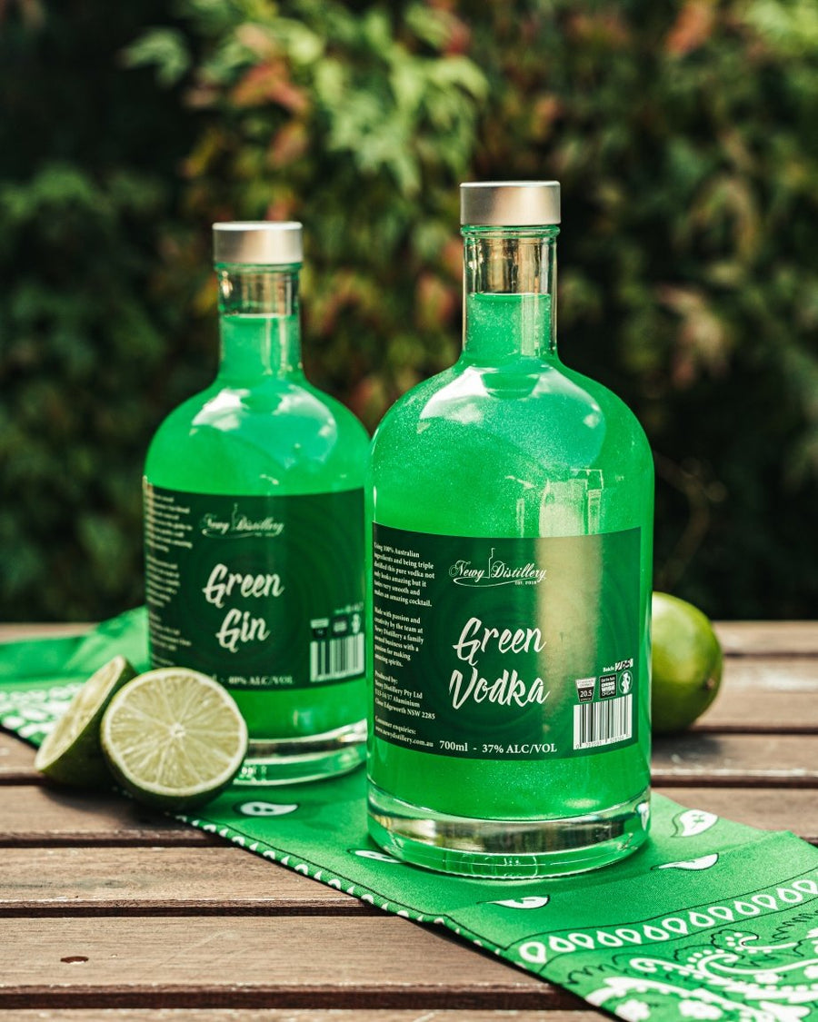 Green Shimmer Gin 500ml and Vodka 700ml bottle. Displayed on table with limes.Newy Distillery.
