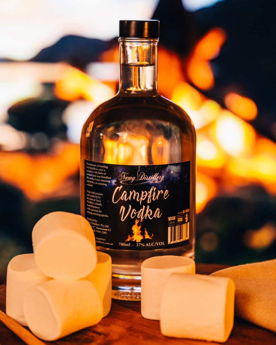 Newy Distillery Campfire Vodka with Shimmer. Marshmallow flavoured vodka. 700ml bottle next to marshmallows and campfire.