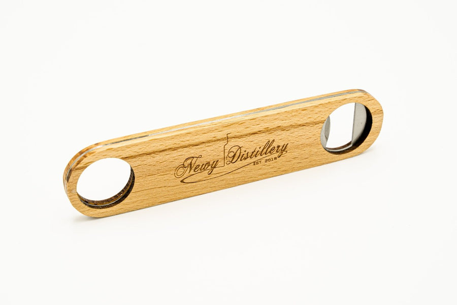 Bartender's Wooden Bottle  Opener by Newy Distillery. Stood on its side on table. Newy Distillery logo engraved on top.