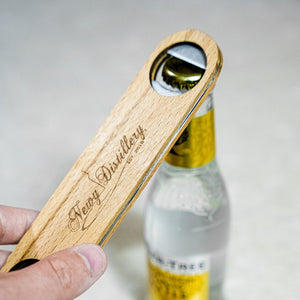 Bartender's Wooden Bottle  Opener by Newy Distillery. Person opening bottle of tonic water.. Newy Distillery logo engraved on top.