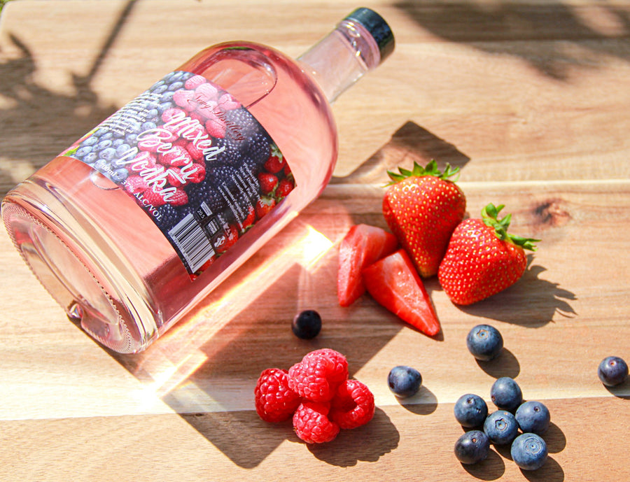 Mixed Berry Fruit Infused Vodka by Newy Distillery. 700ml bottle. Served on wooden board with fresh strawberries, raspberries and blueberries.