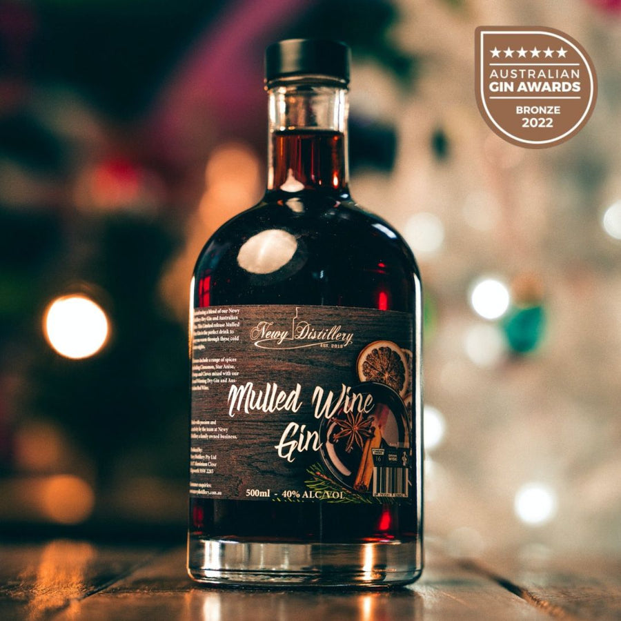 Mulled Wine Gin by Newy Distillery. Award Winning Gin. 500ml bottle displayed in Christmas scene with white Christmas tree.